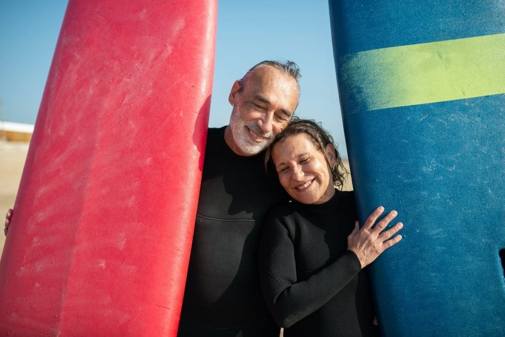 older man and women couple wearing wetsuits