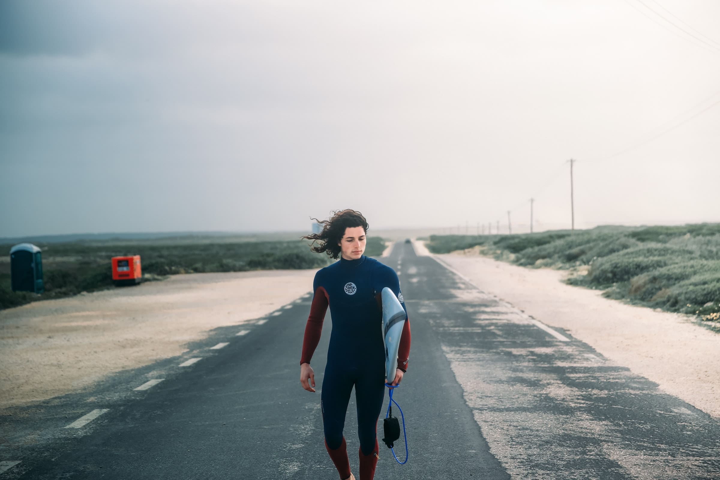 A man wearing a wetsuit on the beach